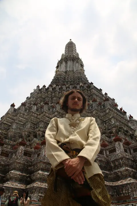 Axel in traditional attire in front of a temple in Bangkok